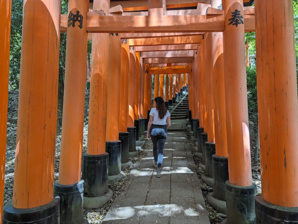 girl walking through tori gates in kyoto